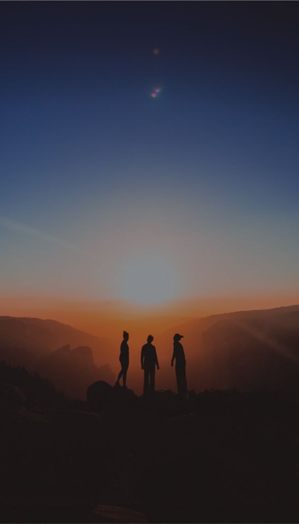 People standing in front of a sunrise